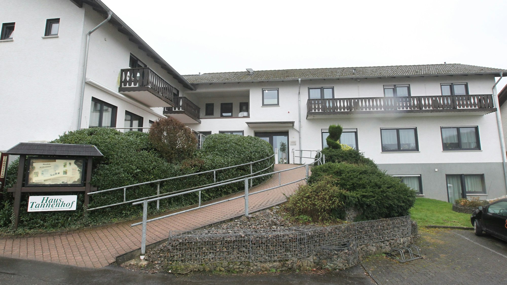 Das Bild zeigt die Vorderseite von Haus Tannenhof mit einer geschwungenen Rampe zum Eingang.