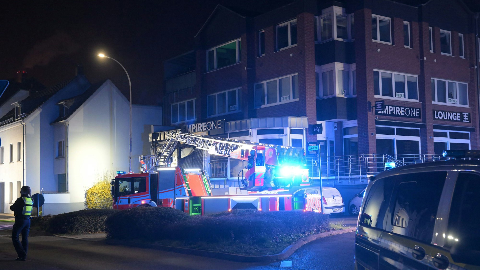 Feuerwehr und Polizei stehen vor einem Haus an der Jakobstraße/Johann-Wilhelm-Lindlar-Straße in Bergisch Gladbach.