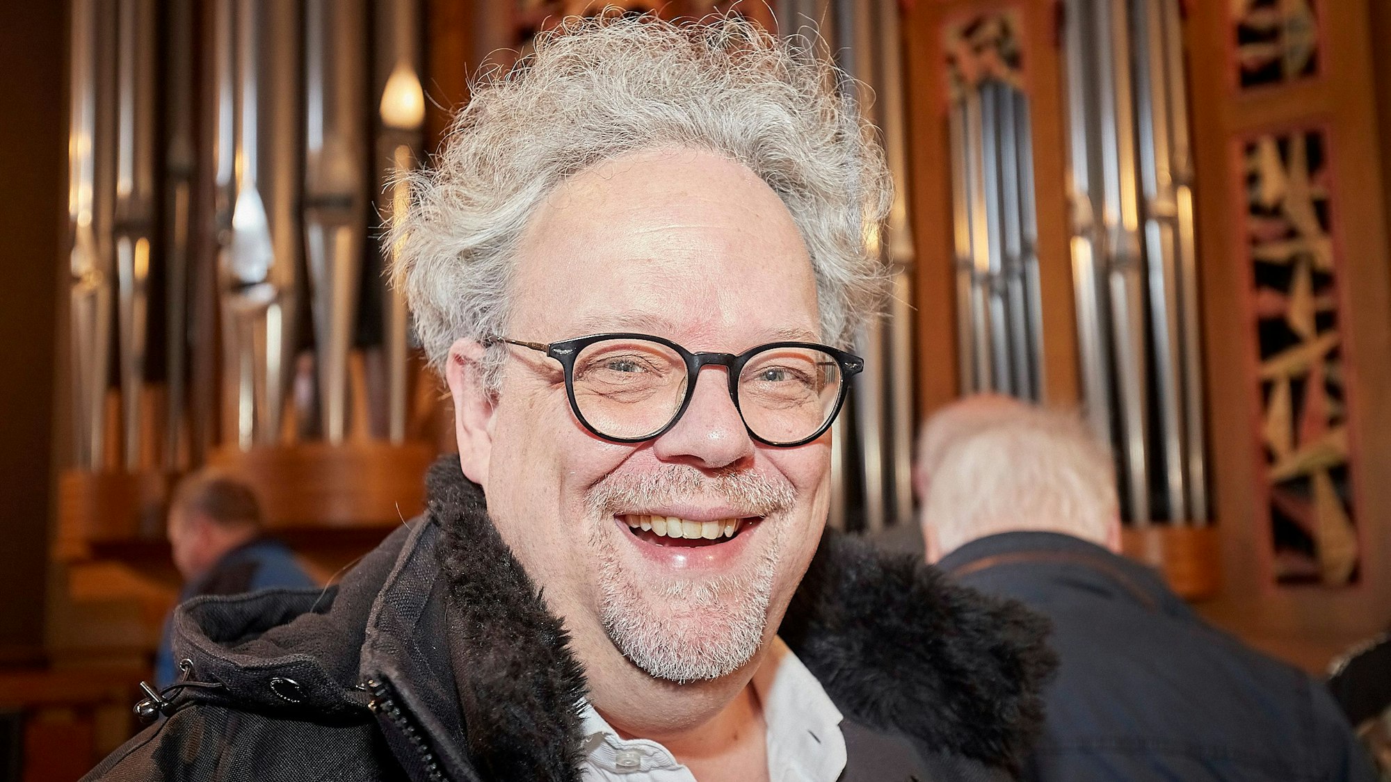 Erik Arndt ist Leiter von insgesamt fünf Chören. Er steht vor der Orgel in der Mechernicher Pfarrkirche.