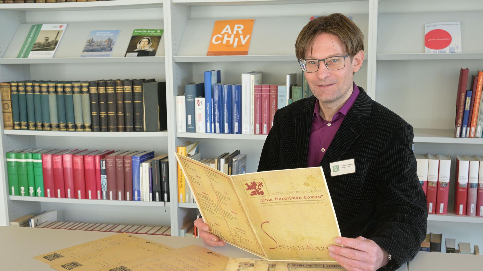 Auch früher wusste man fein zu speisen: Archivar Michael Krischak-Wareeyan mit einer historischen Speisekarte.