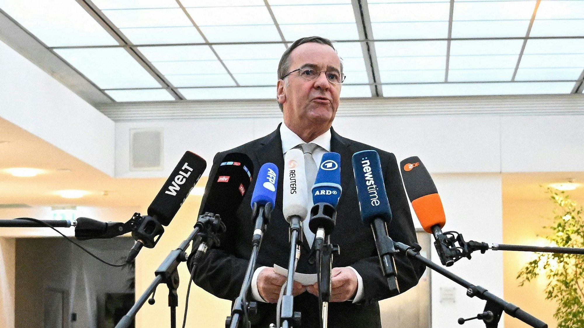 Der deutsche Verteidigungsminister Boris Pistorius (SPD) beantwortet Fragen von Medienvertretern zur Abhöraffäre bei der deutschen Luftwaffe. Vor ihm sind mehrere Mikrofone aufgebaut.