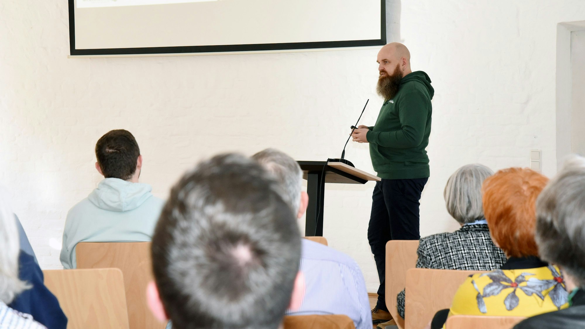 Martin Mikat aus Wallefeld steht am Mikrofon und hält vor Publikum einen Vortrag.