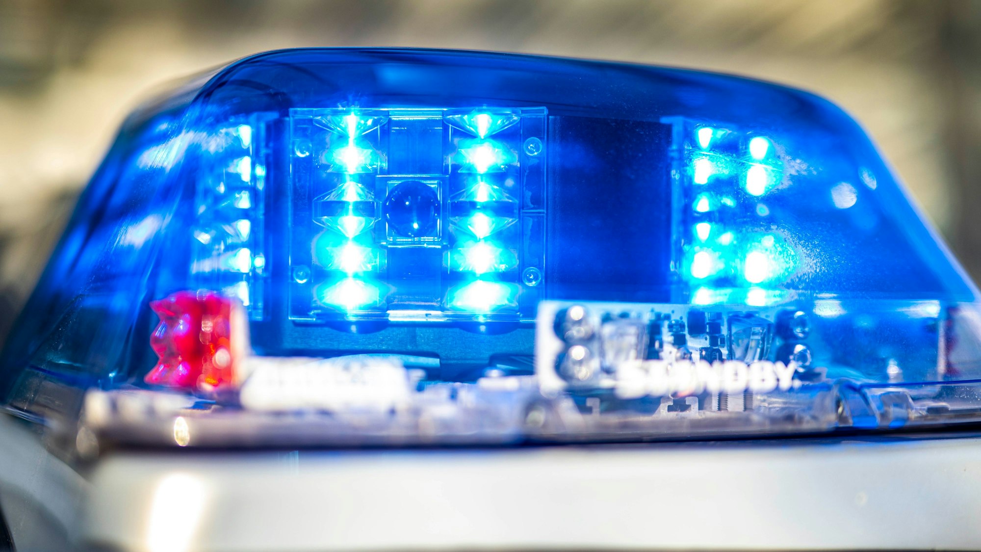 Das Blaulicht an einem Polizeiwagen ist eingeschaltet.