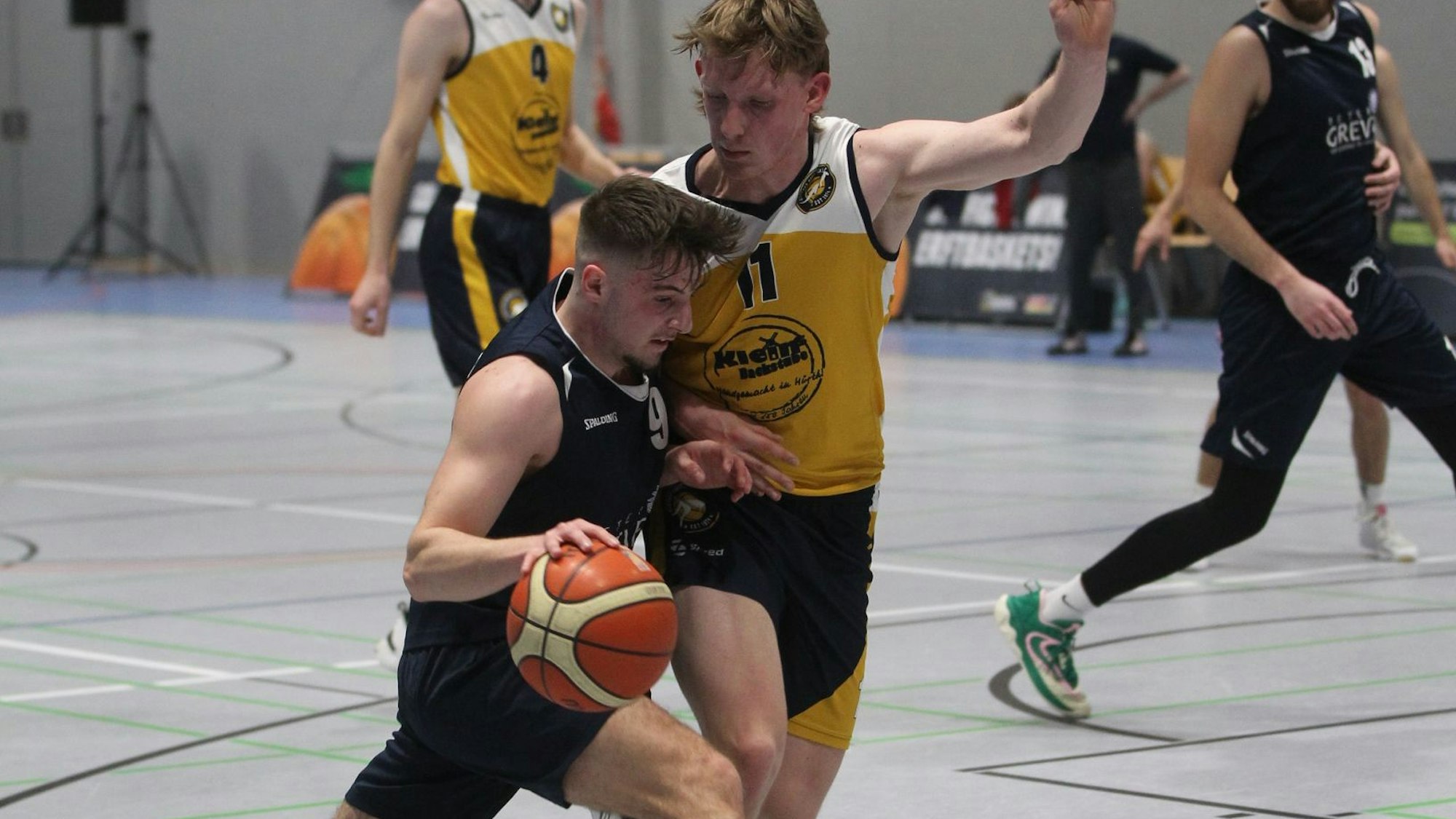 Jan Züll hält mit dem linken Arm einen Gegner von sich fern, mit dem rechten führt er den Ball.