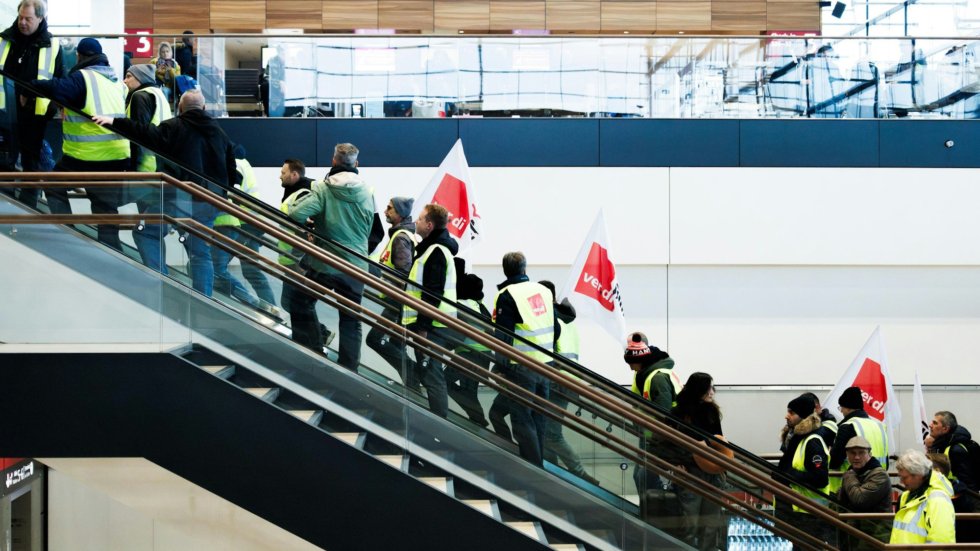Mitarbeiter der der Unternehmenssparte Lufthana Technik demonstrieren mit Fahnen in der Abflughalle im Terminal 1 des Flughafens BER.