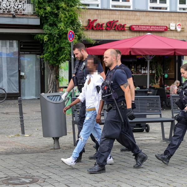 Polizisten führen einen mutmaßlichen Handydieb auf dem Kölner Heumarkt ab.