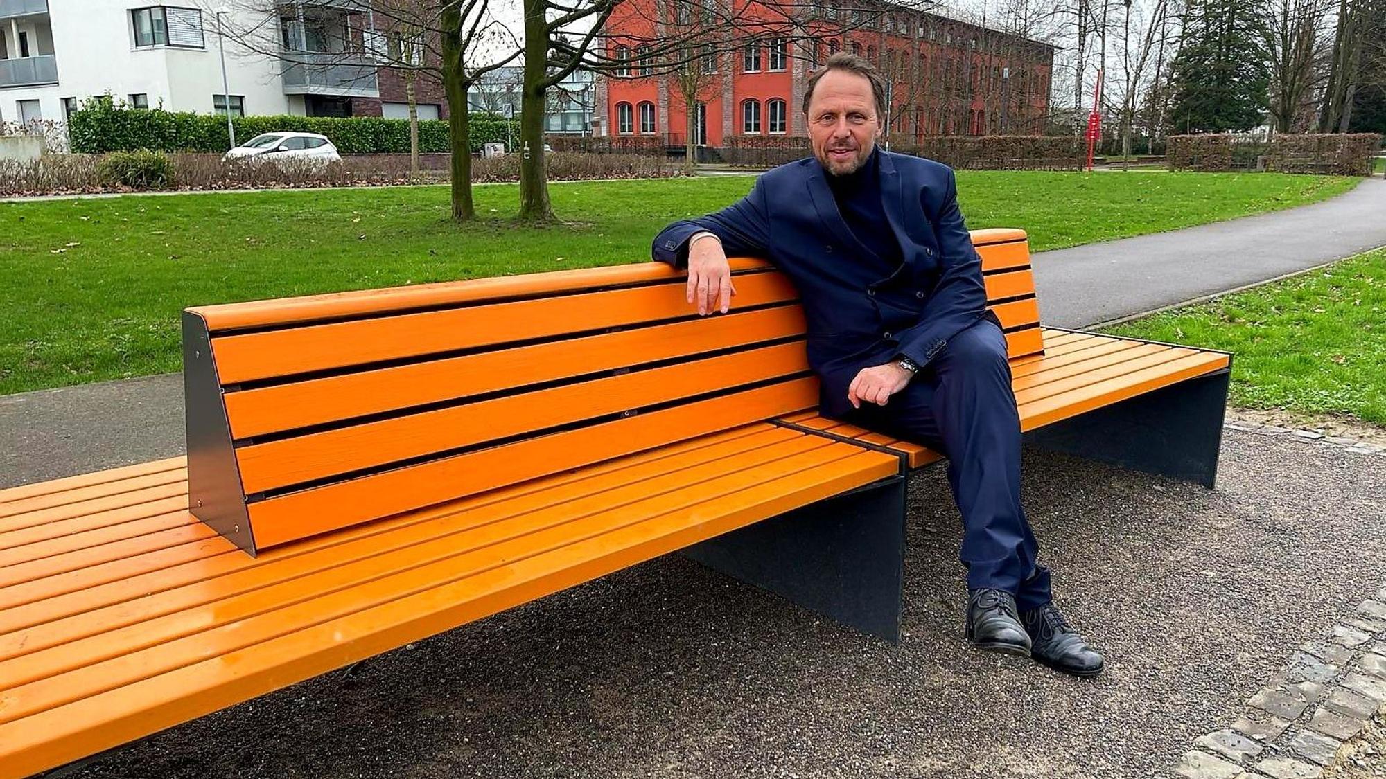 Der Leverkusener OB (Oberbürgermeister) Uwe Richrat (SPD) sitzt auf der vom Zonta-Club Leverkusen aufgestellten orangenen Bank in der Neuen Bahnstadt Opladen, auf der Susanne Wedewer ihn (und demnächst andere bekannte Menschen der Stadt) zum Thema Frauenrechte, Gleichstellung, Sexismus, Gewalt gegen Frauen befragte.