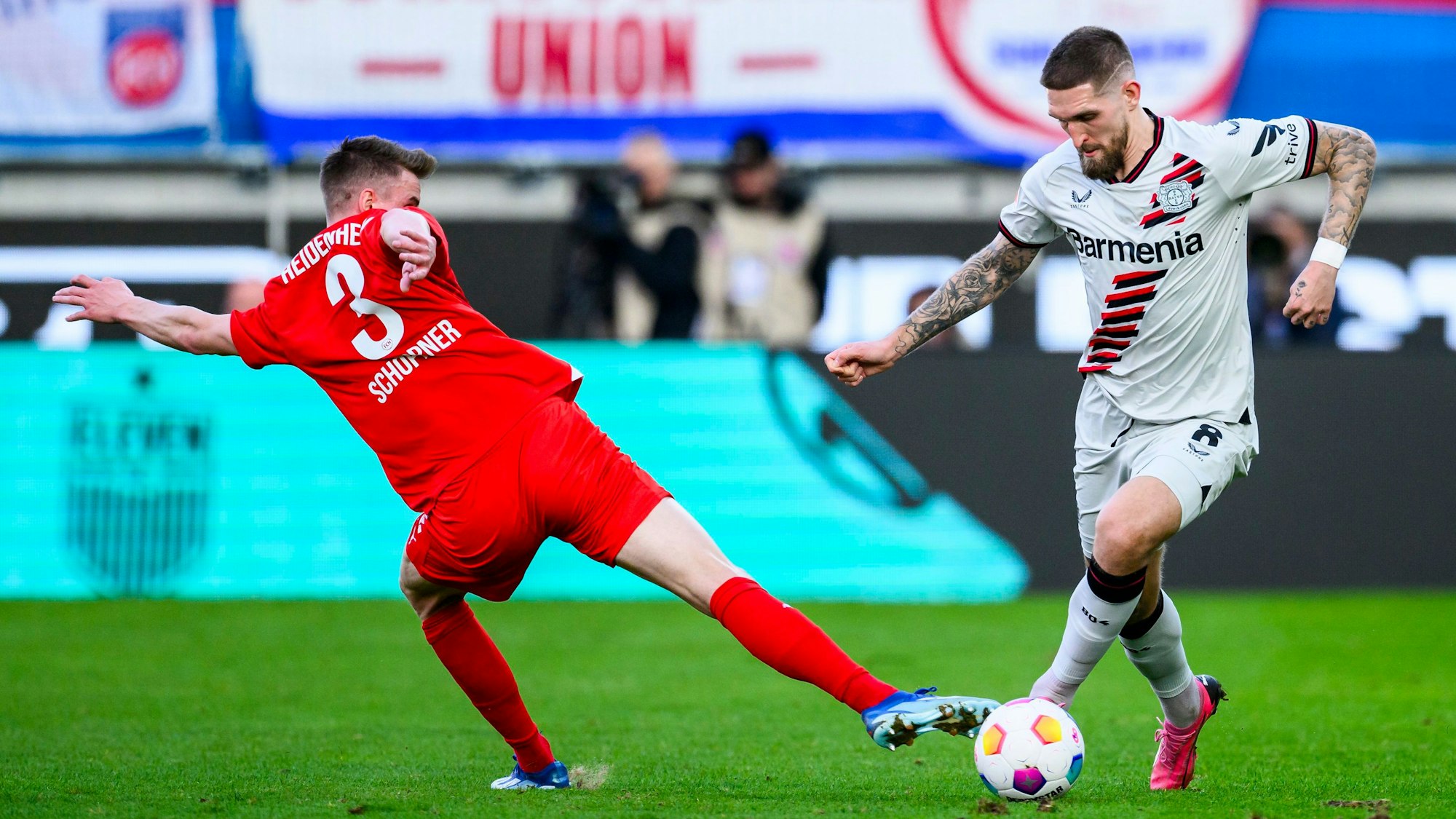Leverkusens Robert Andrich (r) in Aktion gegen Heidenheims Jan Schöppner (l).