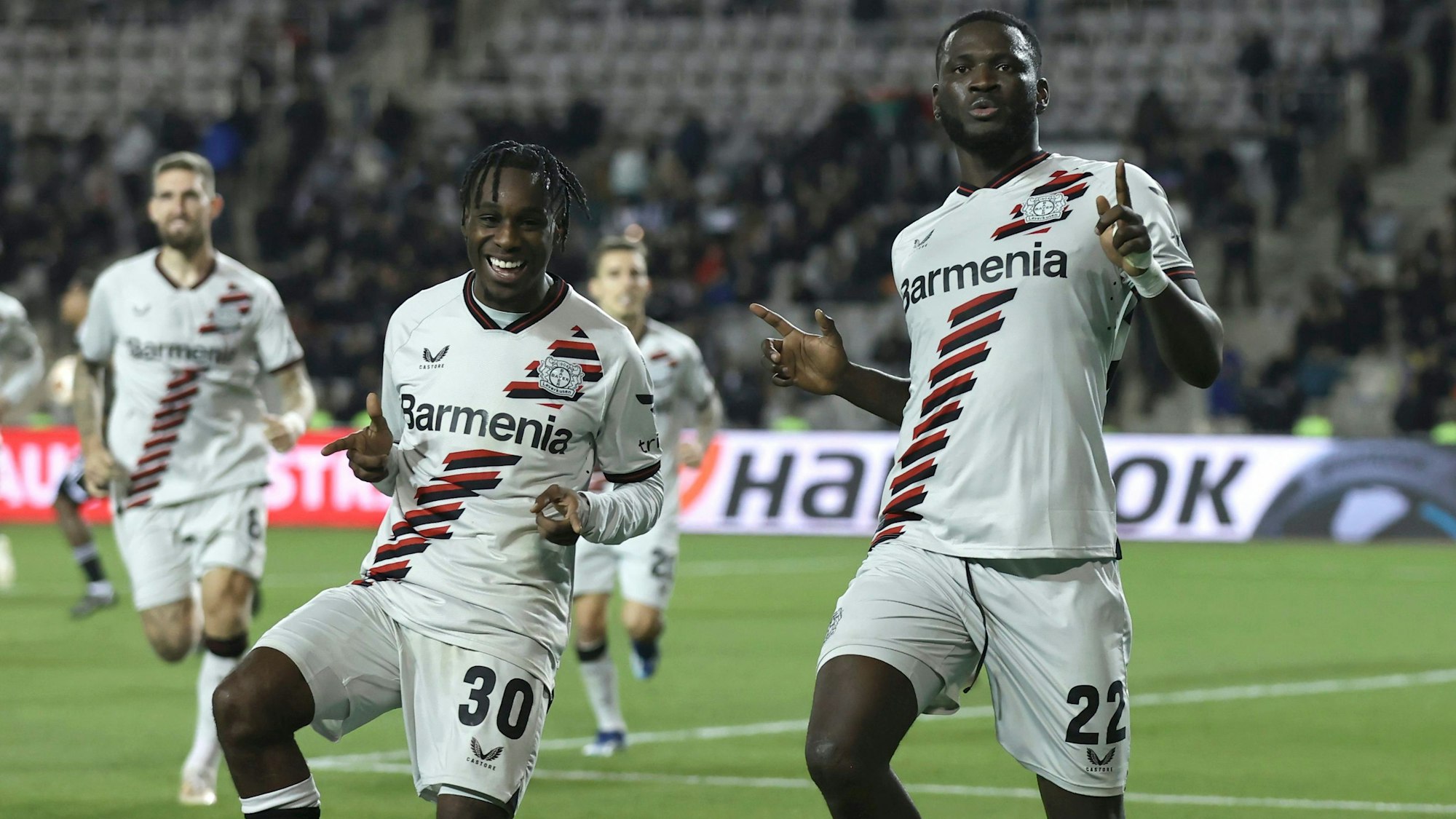 Victor Boniface (r) von Bayer Leverkusen jubelt nach seinem Tor mit seinem Mitspieler Jeremie Frimpong (l) in Baku gegen Karabach im November 2023.