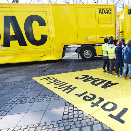 Kinder stehen auf dem Neumarkt vor einem großen, gelben ADAC-Laster.