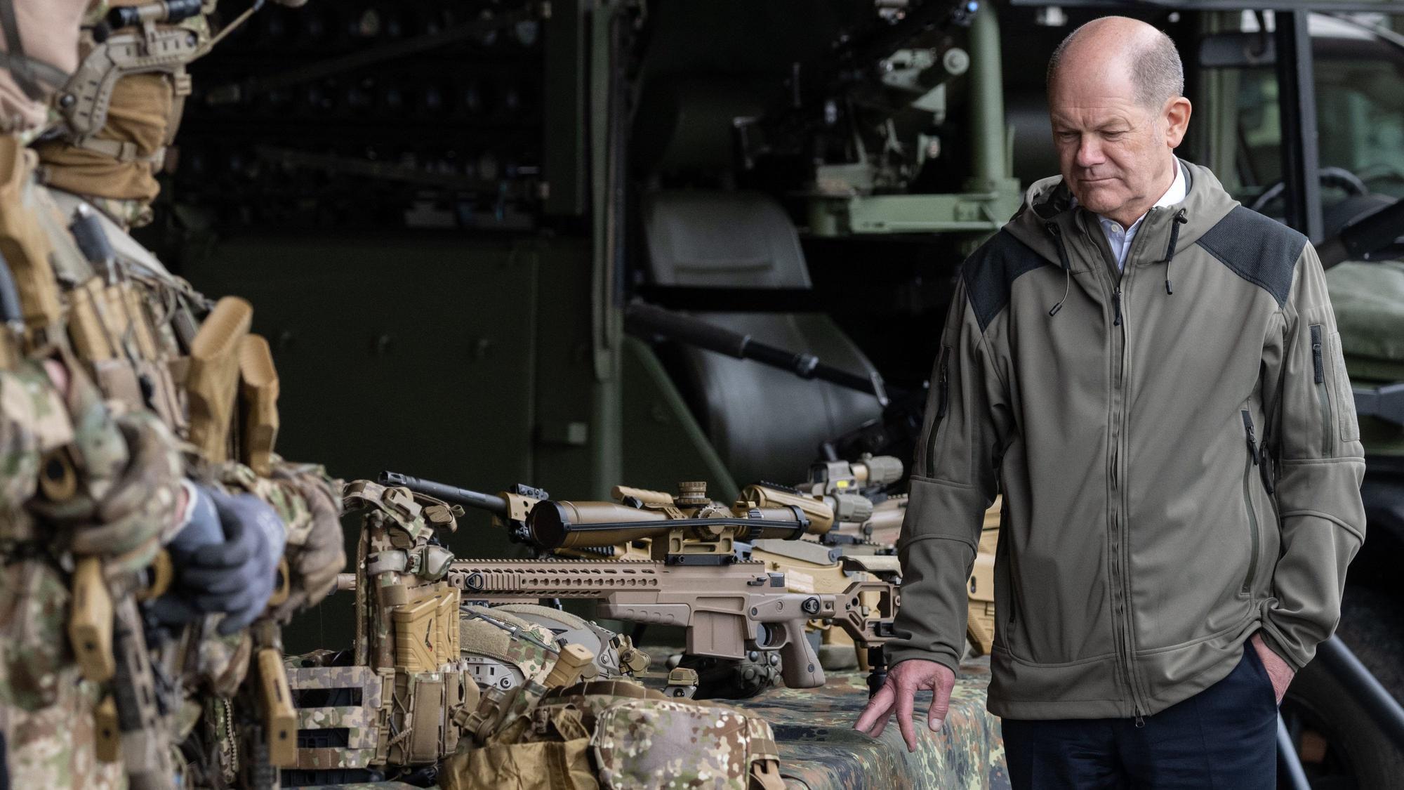 Bundeskanzler Olaf Scholz betrachtet Waffen während eines Besuchs beim Kommando Spezialkräfte (KSK) der Bundeswehr. (Archivbild)
