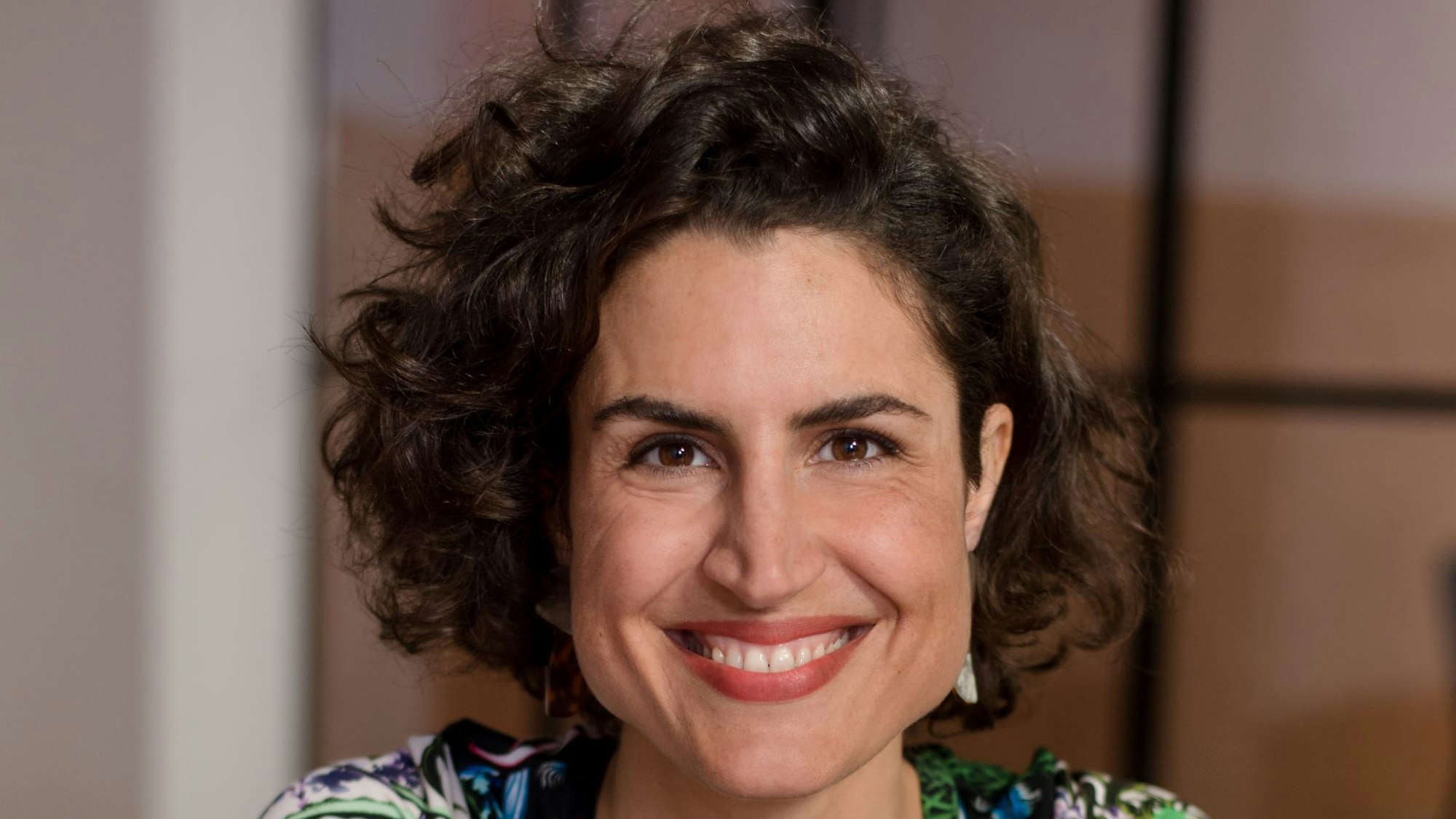 Elly Oldenbourg guckt in die Kamera und lacht.