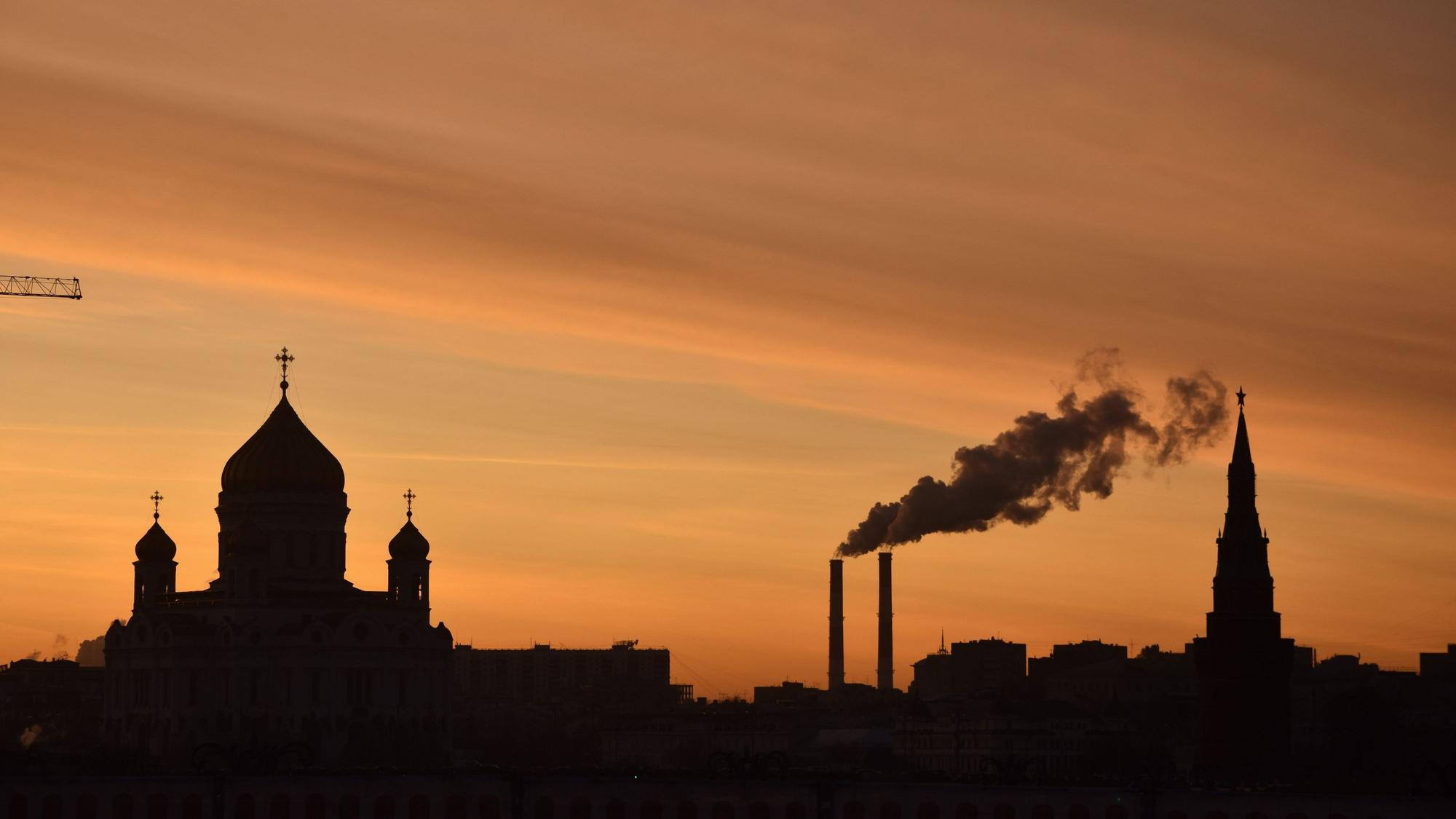 In der russischen Hauptstadt sind die Silhouetten der Christ-Erlöser-Kathedrale, eines Kraftwerks und des Kremls in der Abenddämmerung zu sehen.