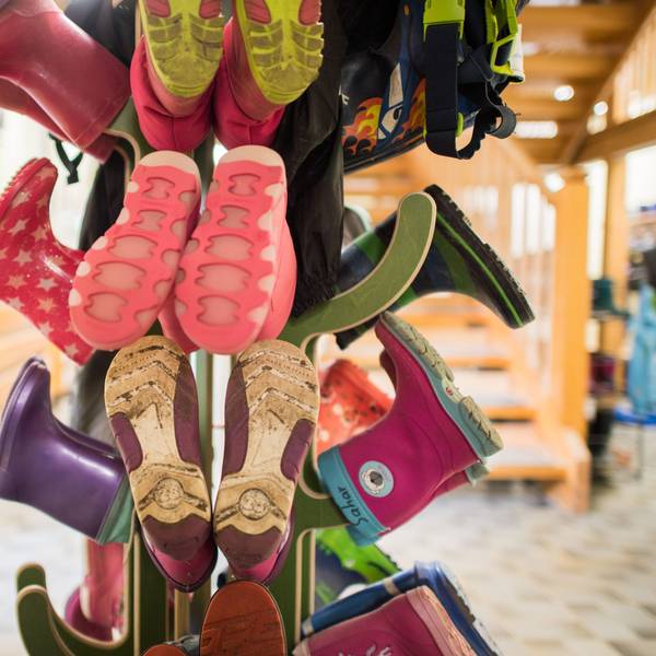 Gummistiefel für Kinder sind an einer Garderobe in einer Kindertagesstätte zu sehen.