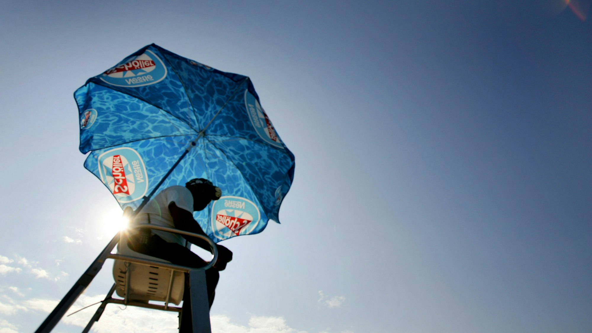 Ein Bademeister sitzt auf seinem Sitz im Stadionbad.