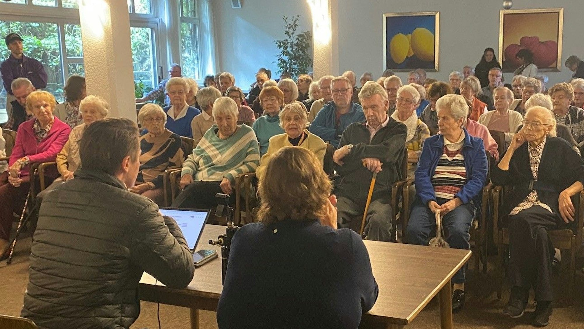 Zu sehen ist die Versammlung der Bewohner im Speisesaal des Seniorenheims.