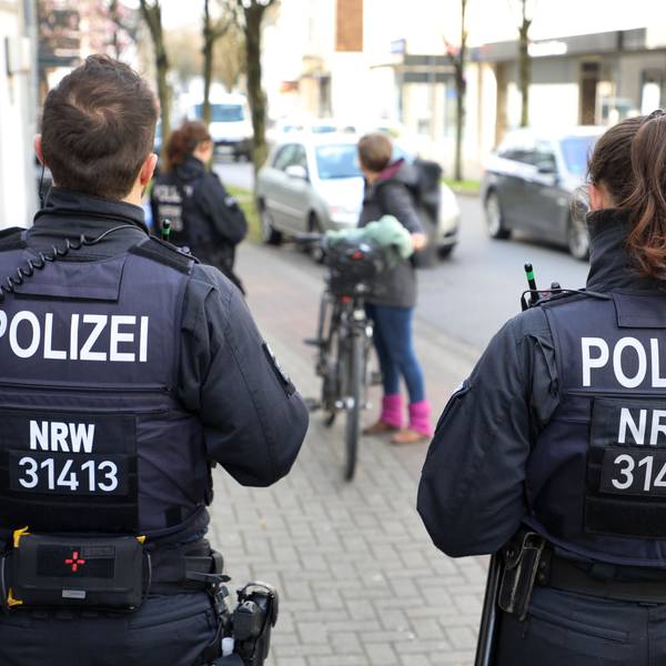 Polizeibeamte und -beamtinnen der Bereitschaftspolizei kontrollieren eine Fahrradfahrerin in Bergisch Gladbach.