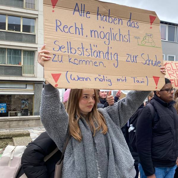 Demonstrierende Schüler halten ein Plakat hoch.