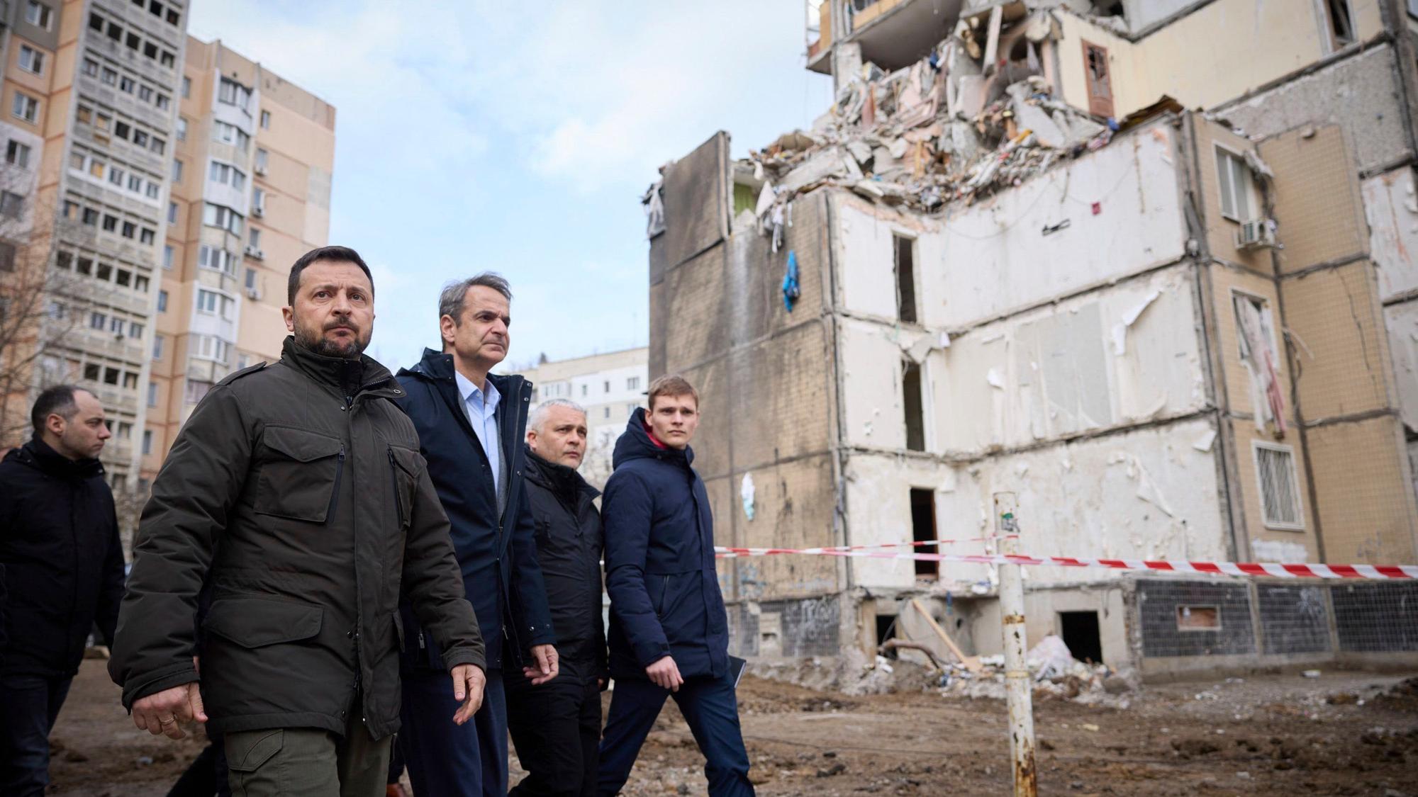 Wolodymyr Selenskyj (l), Präsident der Ukraine, und Kyriakos Mitsotakis (M), Ministerpräsident von Griechenland, gehen durch ein von einem russischen Angriff beschädigtes Wohngebiet in Odessa.