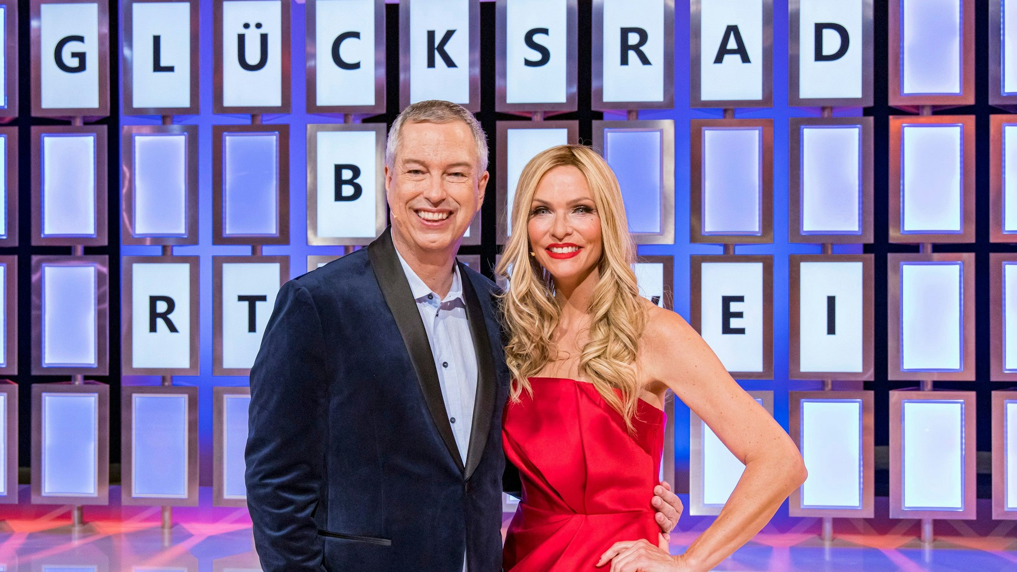 Sonya Kraus und Thomas Hermanns stehen vor der Buchstabenwand vom «Glücksrad».