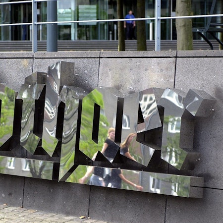 Passanten spiegeln sich am Freitag (18.07.2003) im geputzten Logo der Gothaer Versicherung in Köln. Der Versicherungskonzern gibt bei einer Bilanzpressekonferenz am Montag (21.07.2003) die Zahlen für das vergangene Jahr bekannt. Foto: Roland Scheidemann dpa/lnw |