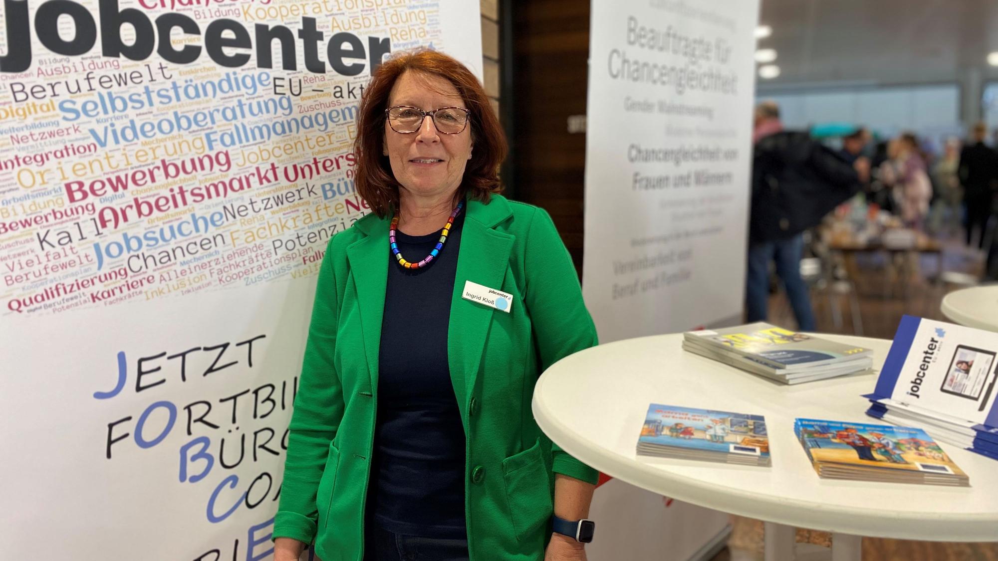 Ingrid Kloß, Beauftragte für Chancengleichheit im Jobcenter Euskirchen steht an ihrem Stand zwischen zwei Plakaten