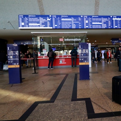 Im Foyer des HBF schauen sich Pendler die Abfahrtstafel an.