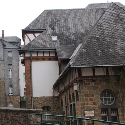 Ein großes, verschachteltes Gebäude aus Bruchstein, Fachwerk und Schiefer.