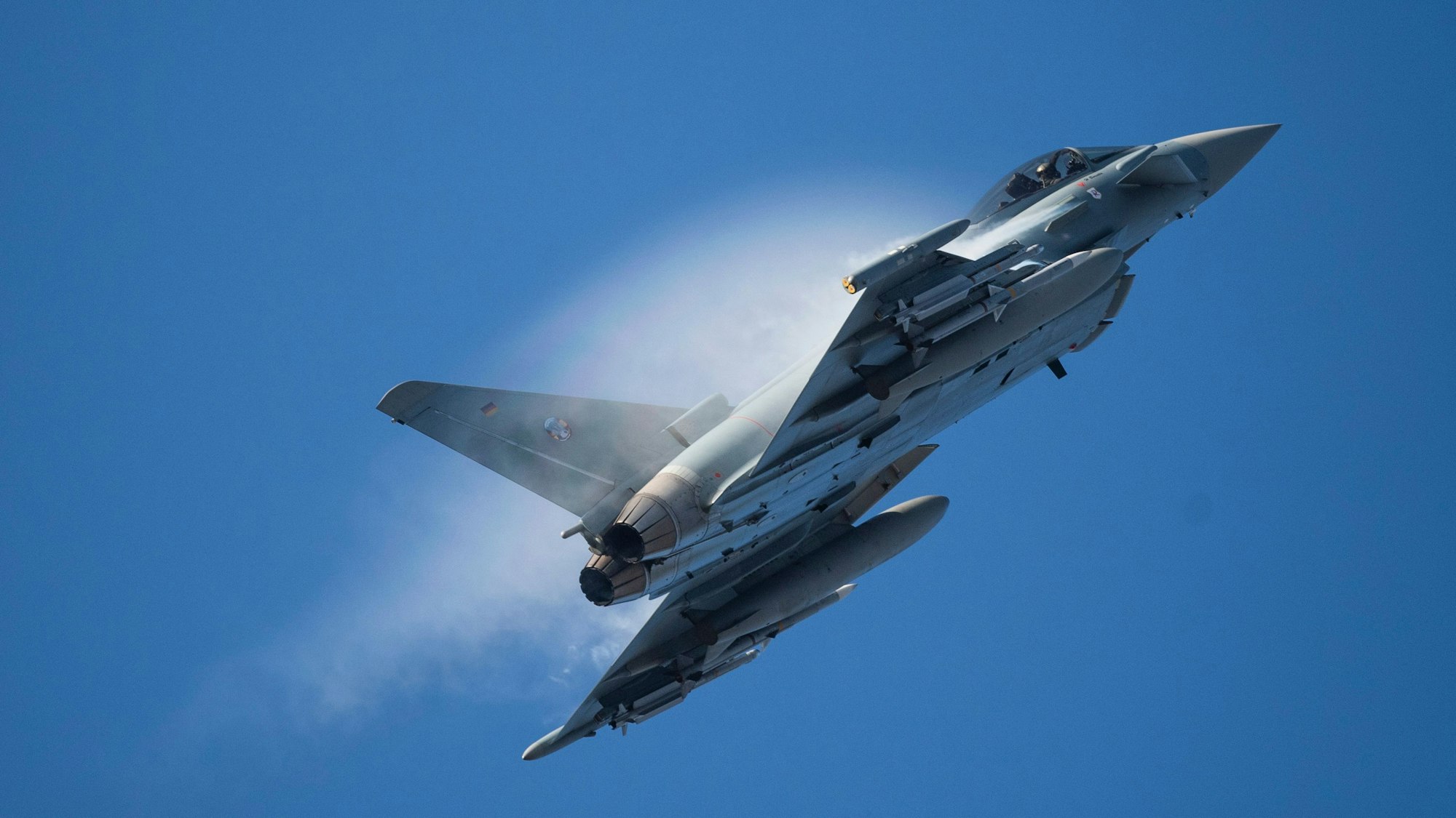Ein Kampfflugzeug vom Typ Eurofighter Typhoon der Luftwaffe fliegt in dichtem Rauch über einem Stützpunkt der Nato. (Archivbild)