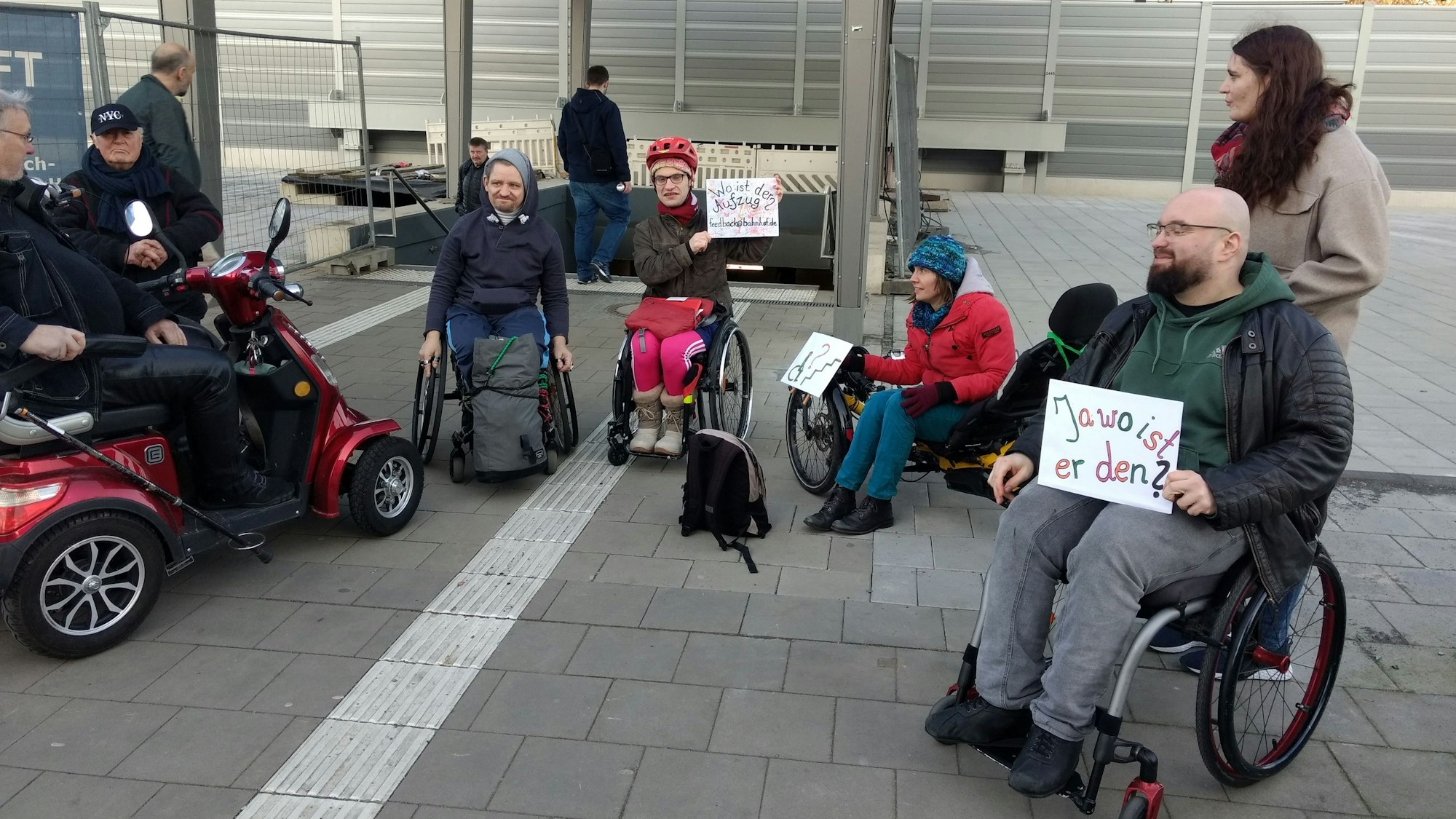 Ilias Emmanuil und weitere Mitstreiter (M.) demonstrieren vor der Unterführung zu den Bahngleisen in Wiesdorf für den Einbau der Aufzüge.