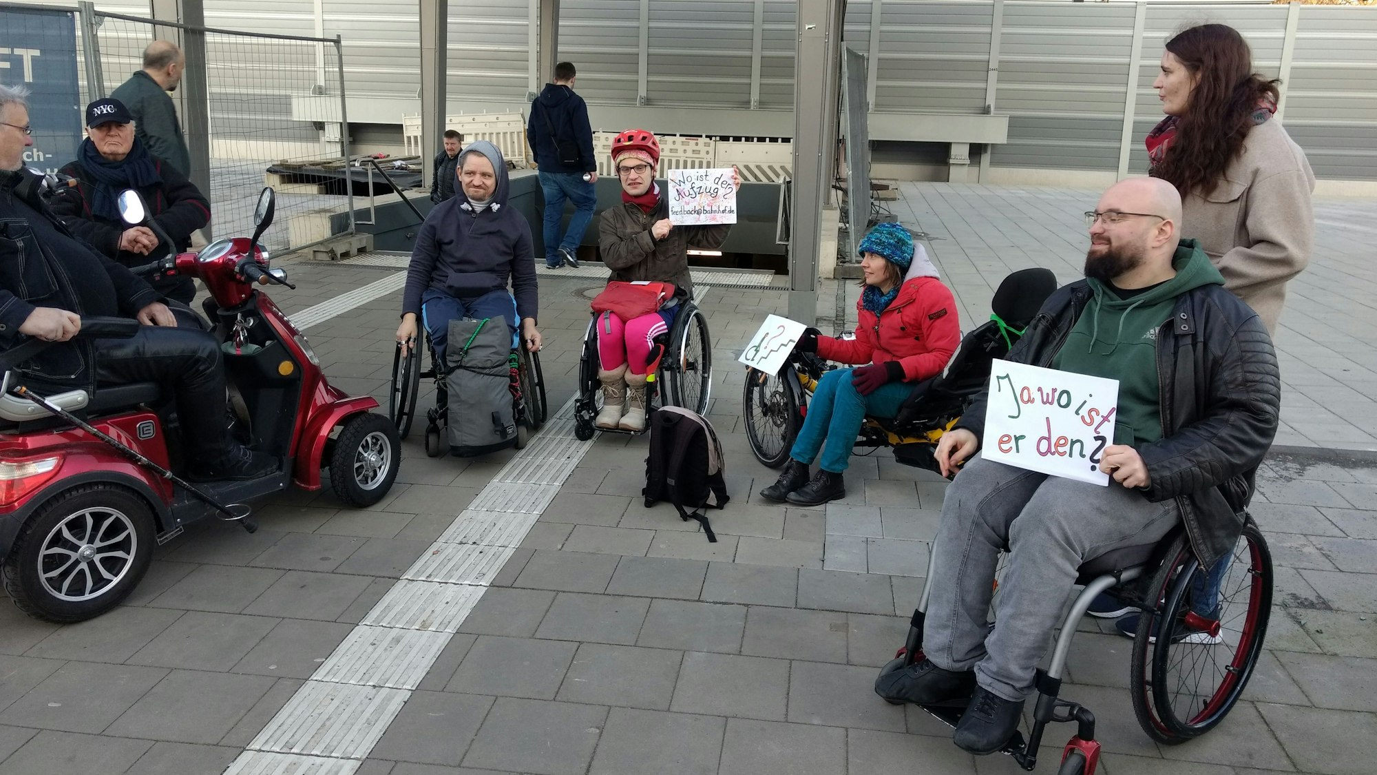 Ilias Emmanuil und weitere Mitstreiter (M.) demonstrieren vor der Unterführung zu den Bahngleisen in Wiesdorf für den Einbau der Aufzüge.