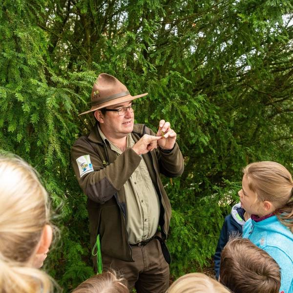 Ein Ranger des Nationalparks Eifel mit Kindern auf einer Tour im Nationalpark.