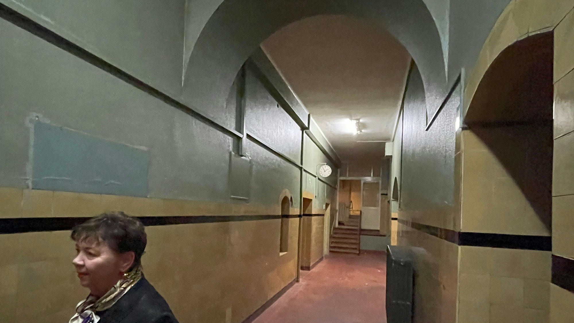 Ein langer Flur mit steinernen Rundbögen.