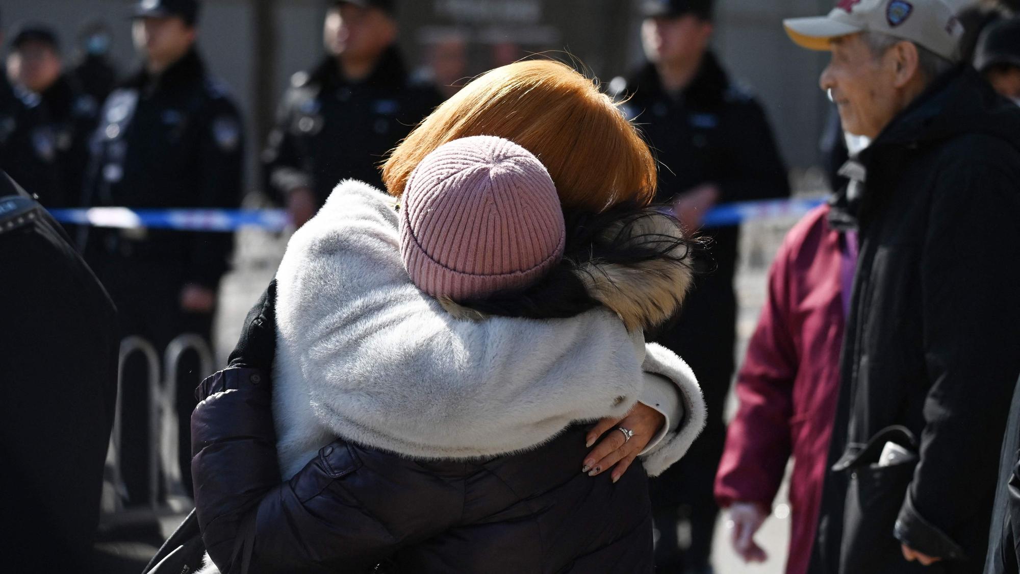 Angehörige von Passagieren des vermissten Fluges MH370 der Malaysian Airlines umarmen sich während einer Versammlung vor der malaysischen Botschaft in Peking am 8. März 2024, dem zehnten Jahrestag des Verschwindens des Fluges.