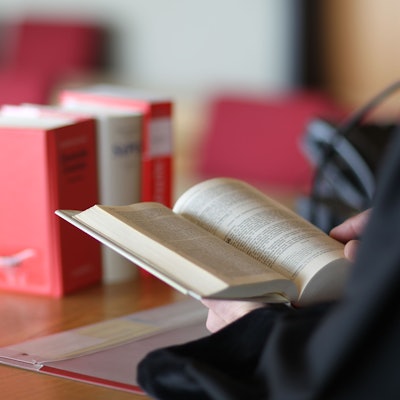 Ein Richter liest in einem Gesetzbuch.