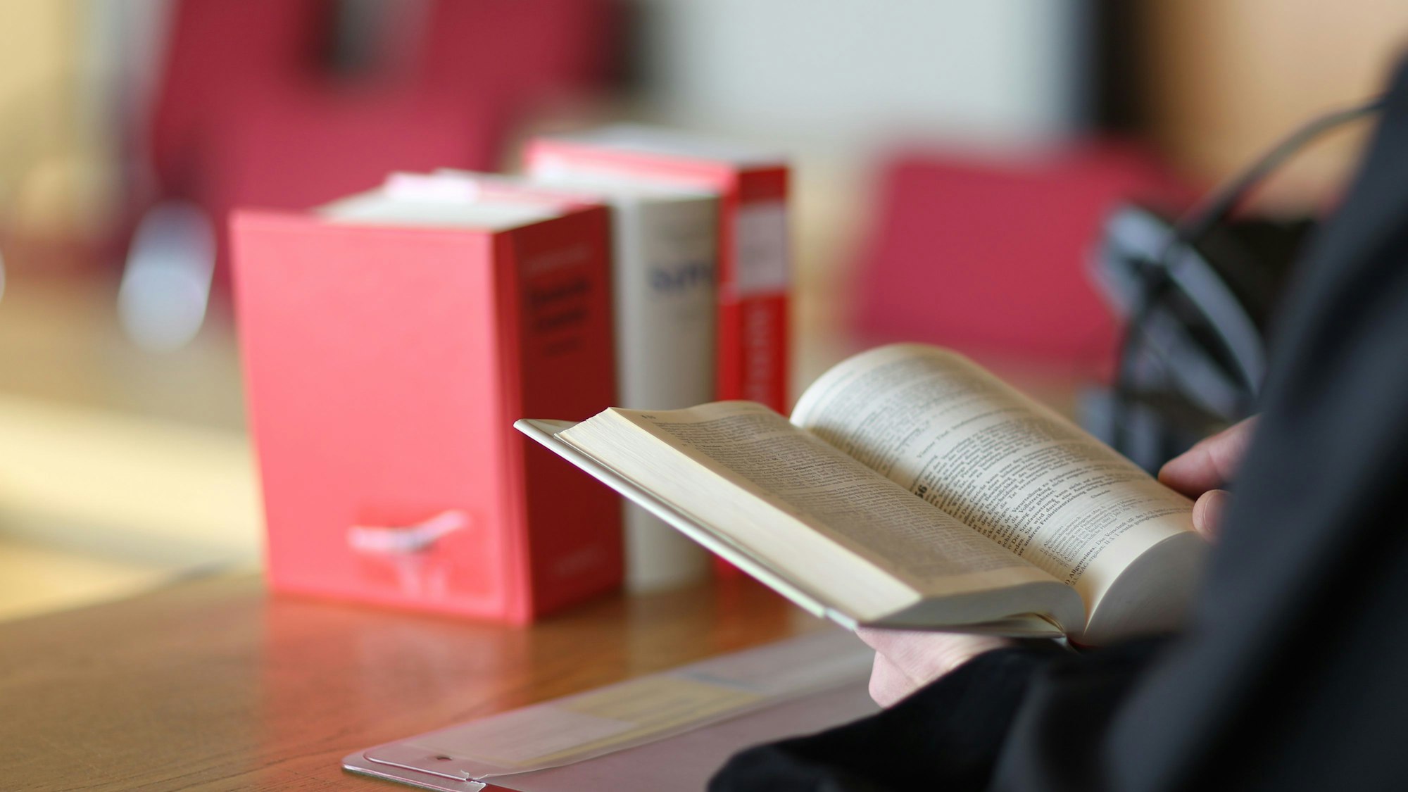 Ein Richter schlägt an seinem Tisch Gesetze nach