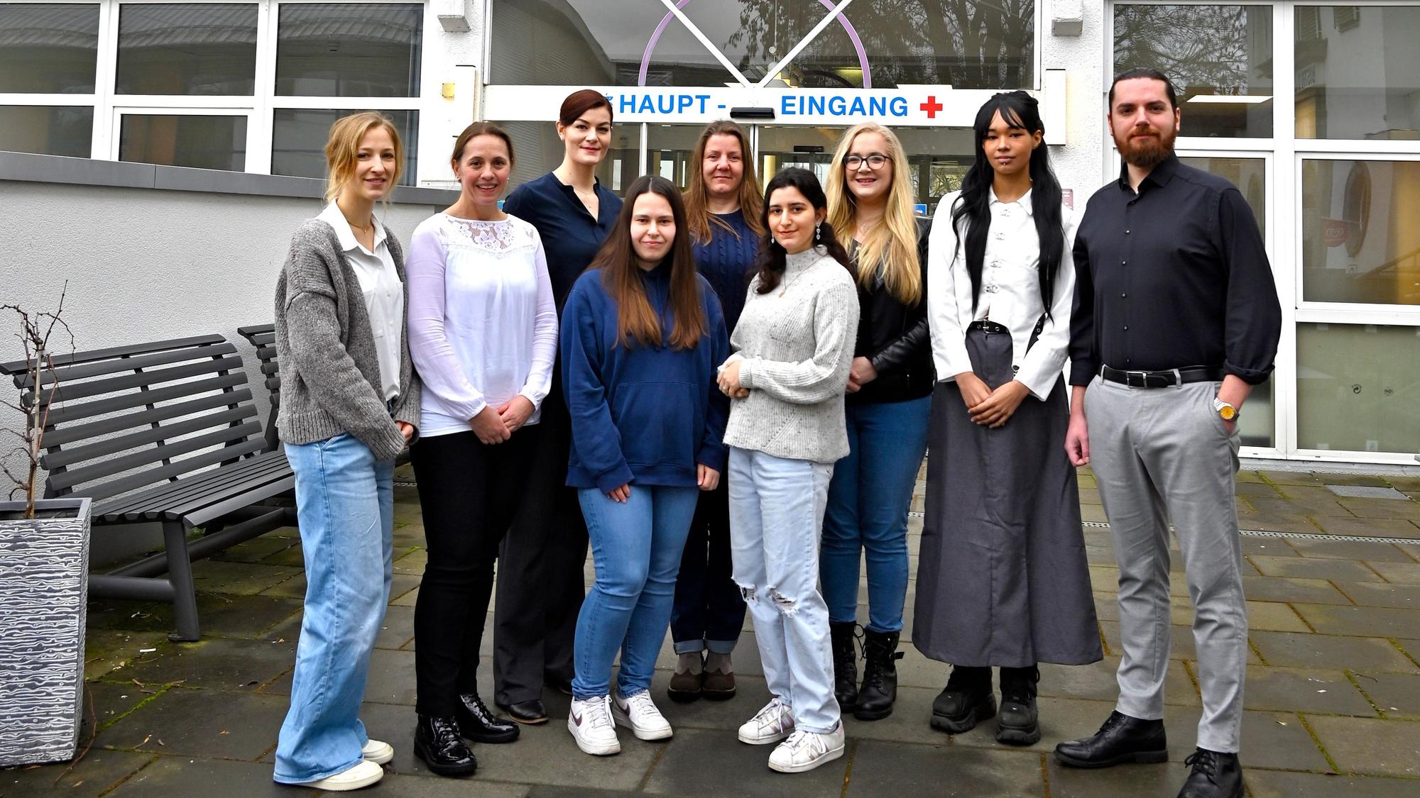 Eine Gruppe von Frauen und Männern vor dem Haupteingang des Sana-Krankenhauses.