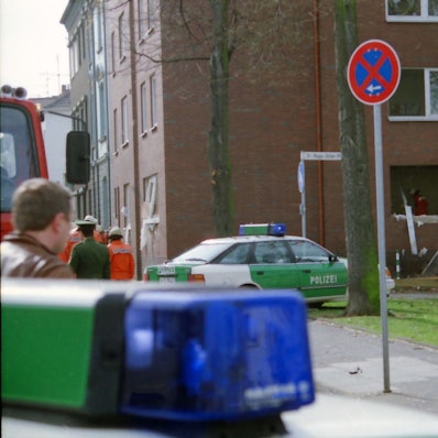 Das Bild zeigt den Tatort einige Zeit nach dem Amoklauf von Euskirchen. Zu sehen sind auch zwei Streifenwagen.