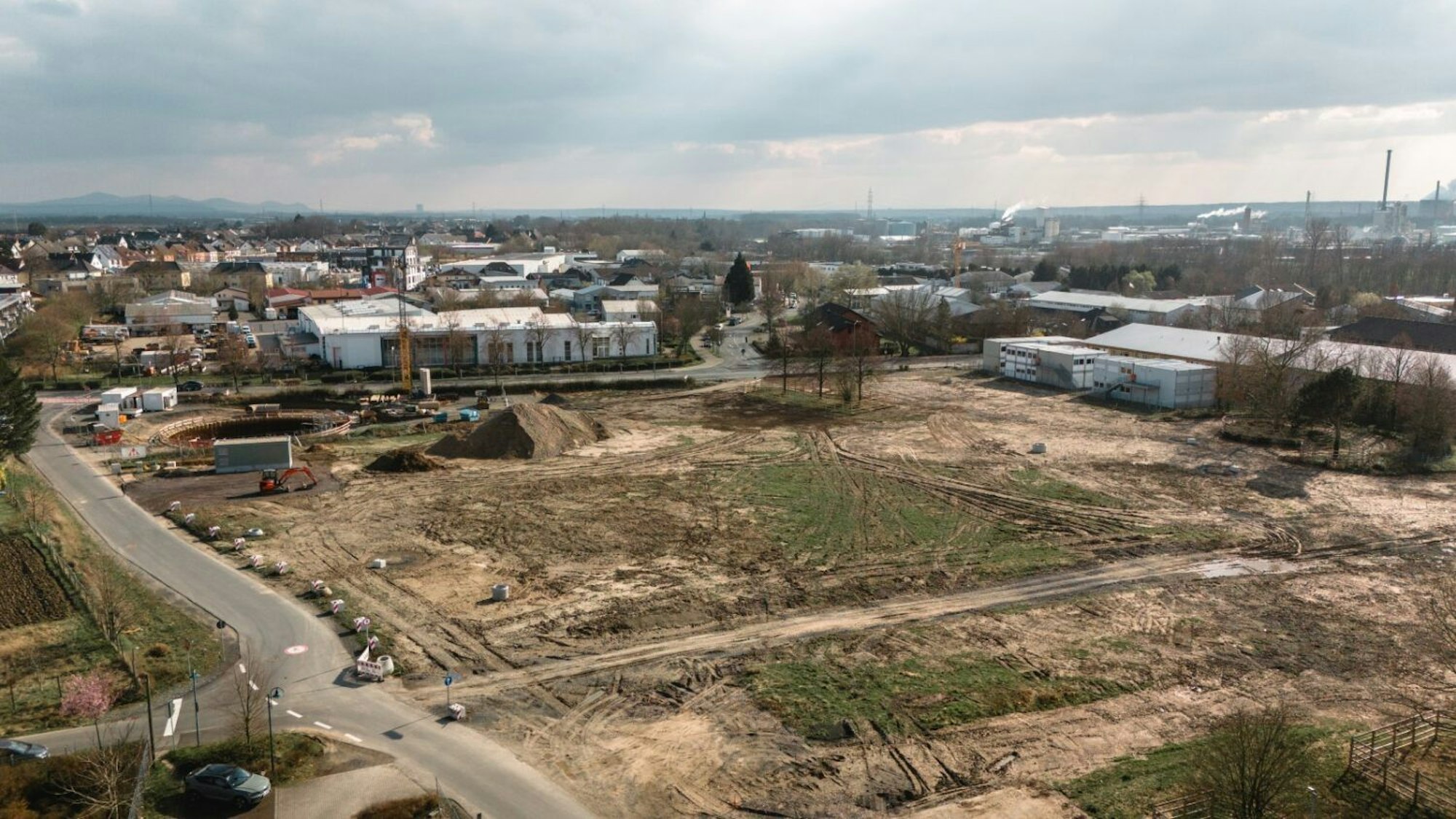 Ein Luftbild zeigt das freigeräumte, mehr als zwei Hektar große Grundstück an der Berliner Straße in Niederkassel-Lülsdorf, auf dem bis zum dritten Quartal 2026 der Erweiterungsbau für das Schulzentrum Nord entstehen soll.