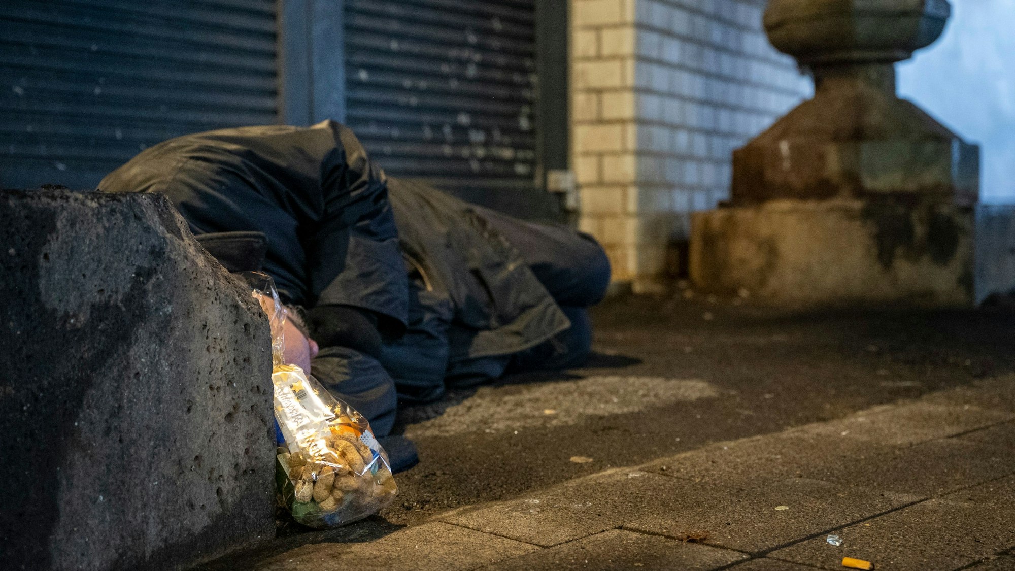 Ein wohnungsloser Mann schläft in Köln auf der Straße (Symbolbild)