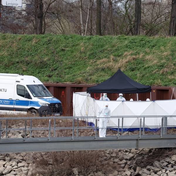 Beamte der Spurensicherung durchkämmen ein Grünstück auf der Landzunge im Mülheimer Hafen.