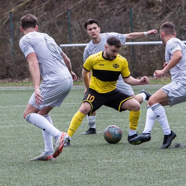 Ein Hohkeppeler Spieler wird mit dem Ball am Fuß von drei Spielern von Germania Teveren umringt.