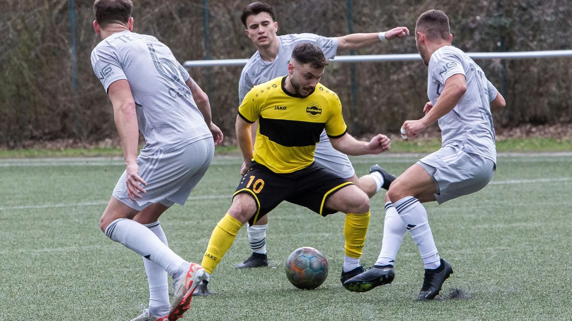 Ein Hohkeppeler Spieler wird mit dem Ball am Fuß von drei Spielern von Germania Teveren umringt.