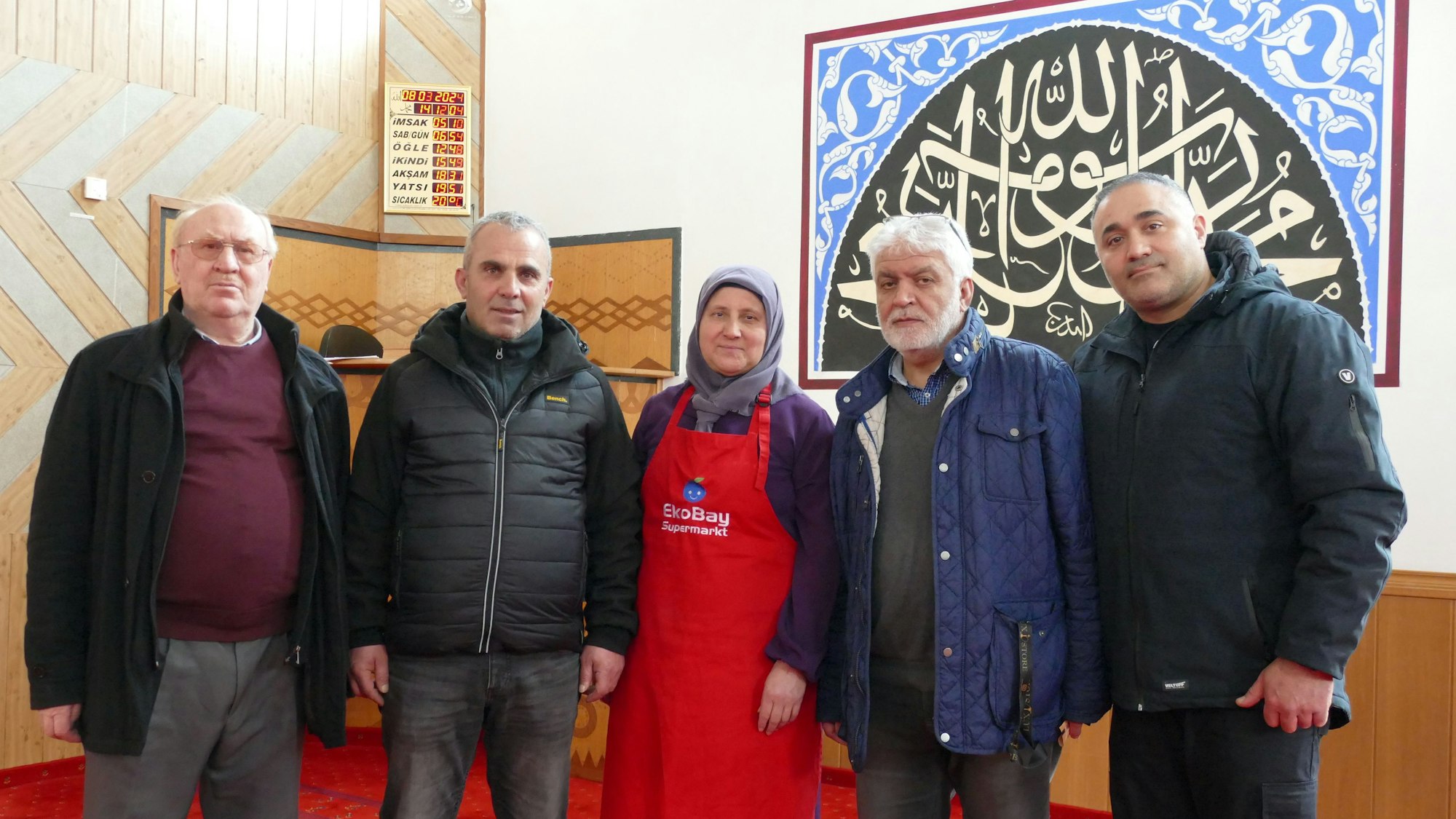 Vier ältere Männer und eine Frau mit Kopftuch