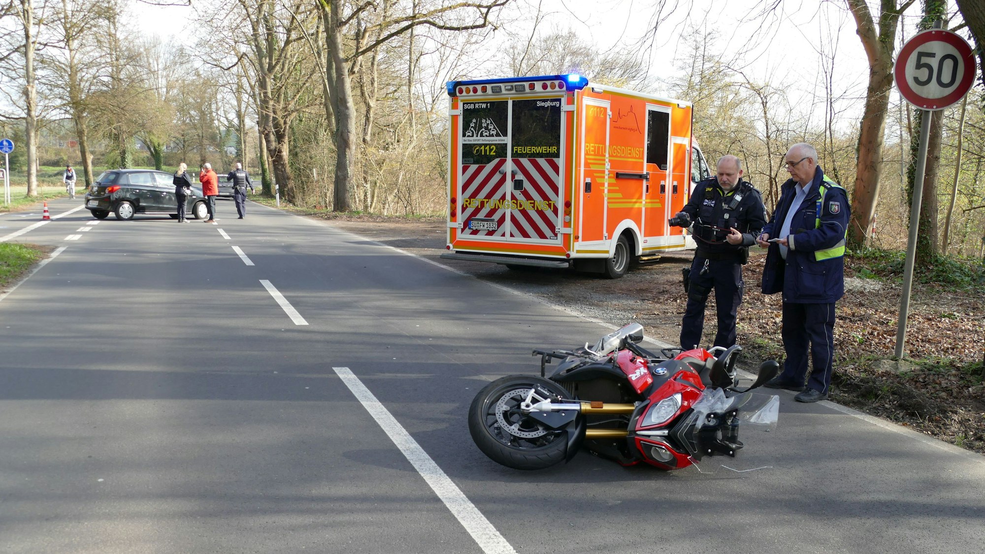 Polizisten begutachten ein Motorrad, das auf der Straße liegt.