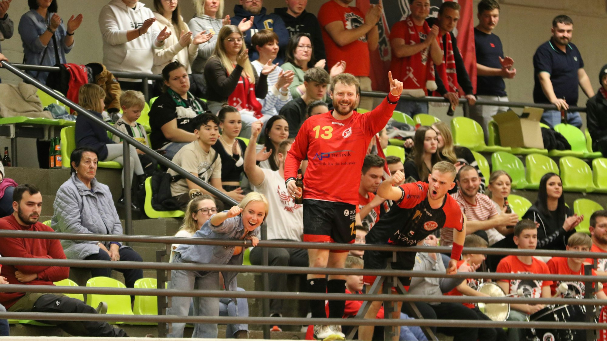 Nach ihren Platzverweisen nehmen René Lönenbach (der einen Zeigefinger erhebt) und Paul Blesse, der motivierend jubelt, auf der Tribüne Platz.