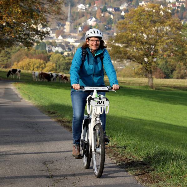 Eine Frau fährt bei Overath einen Berg hinauf.