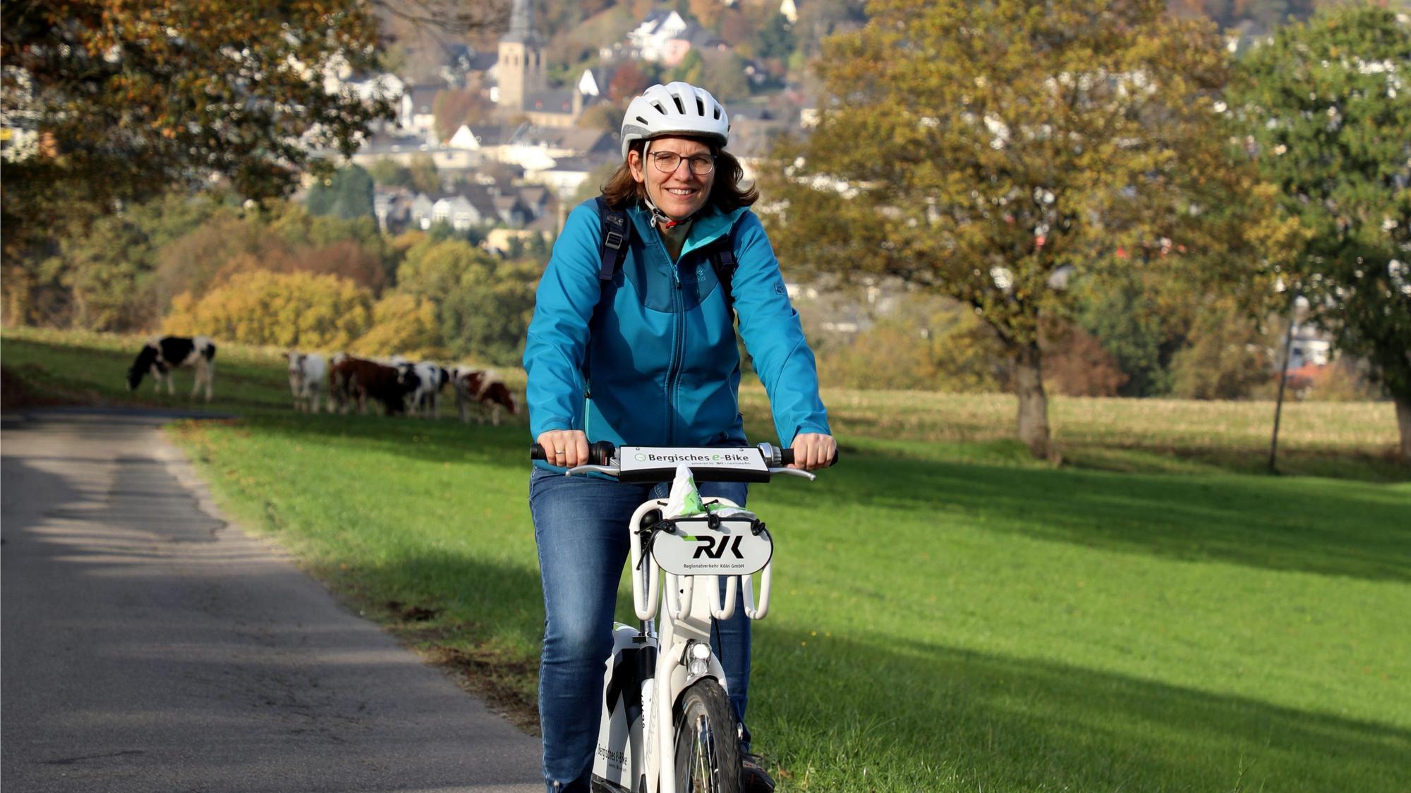 Das Foto zeigt eine Radfahrerin auf einem E-Bike.