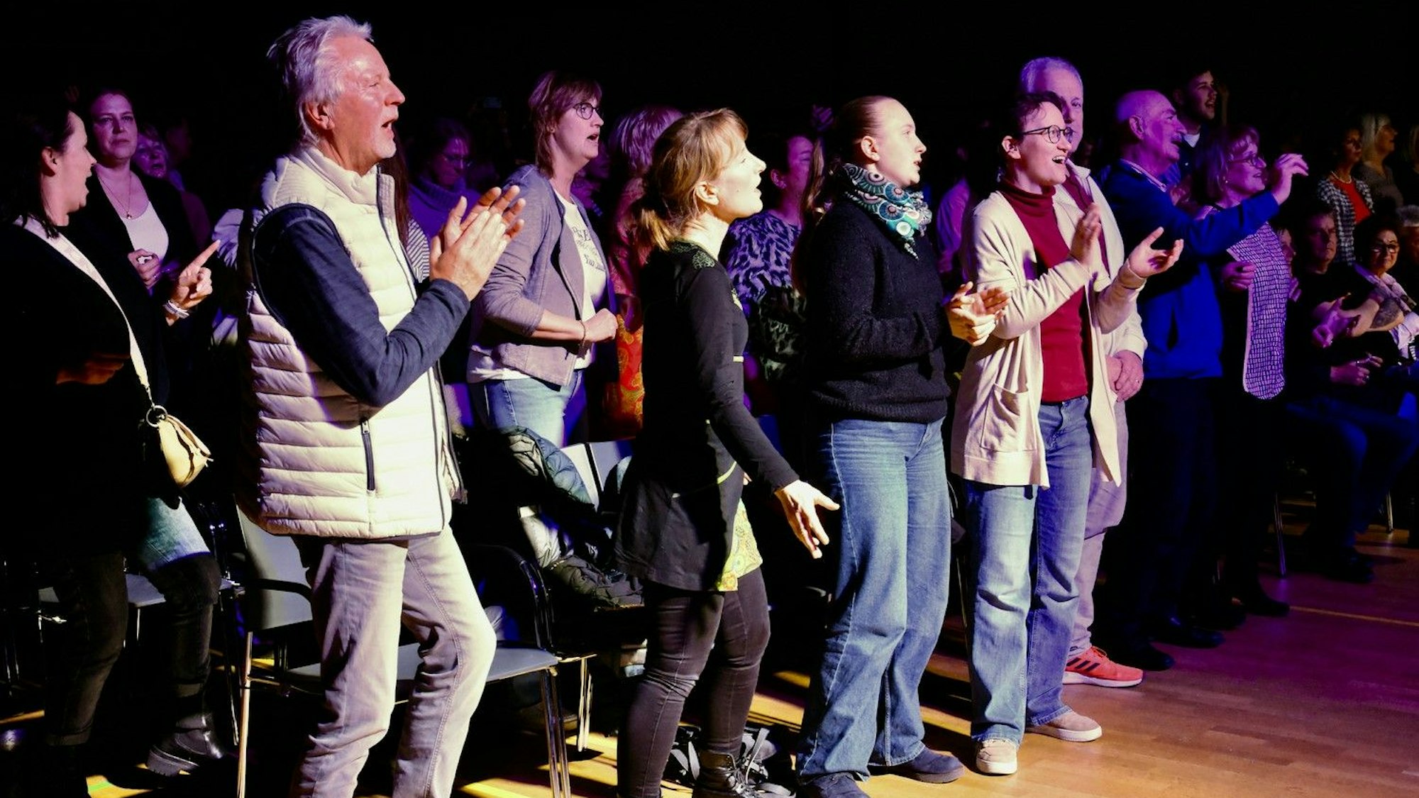 Menschen tanzen und klatschen in die Hände.