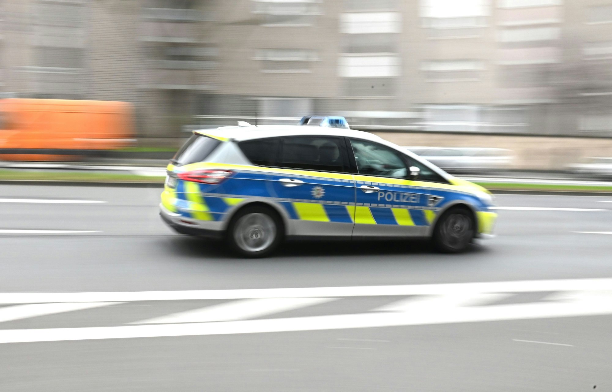 Ein Polizeiauto fährt mit Blaulicht durch eine Stadt. (Symbolbild)